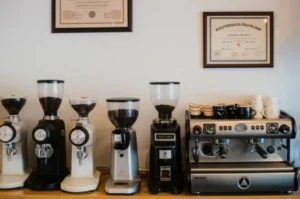 A-beautifully-arranged-modern-coffee-shop-interior,-featuring-an-espresso-machine,-coffee-grinders,-and-coffee-beans,-with-a-barista-certification-hanging-on-the-wall,-creating-a-warm-and-inviting-atmosphere.