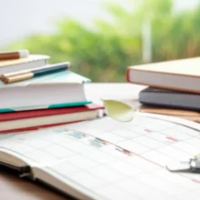 A-neatly-organized-study-desk-featuring-textbooks,-notebooks,-and-a-calendar-marked-for-a-two-week-study-plan,-symbolizing-dedicated-preparation-for-the-Air-Quality-Engineer-written-exam.