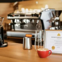 Barista-Level-2-certificate-displayed-on-a-clean-cafe-counter-with-coffee-equipment-and-a-latte-art-coffee.