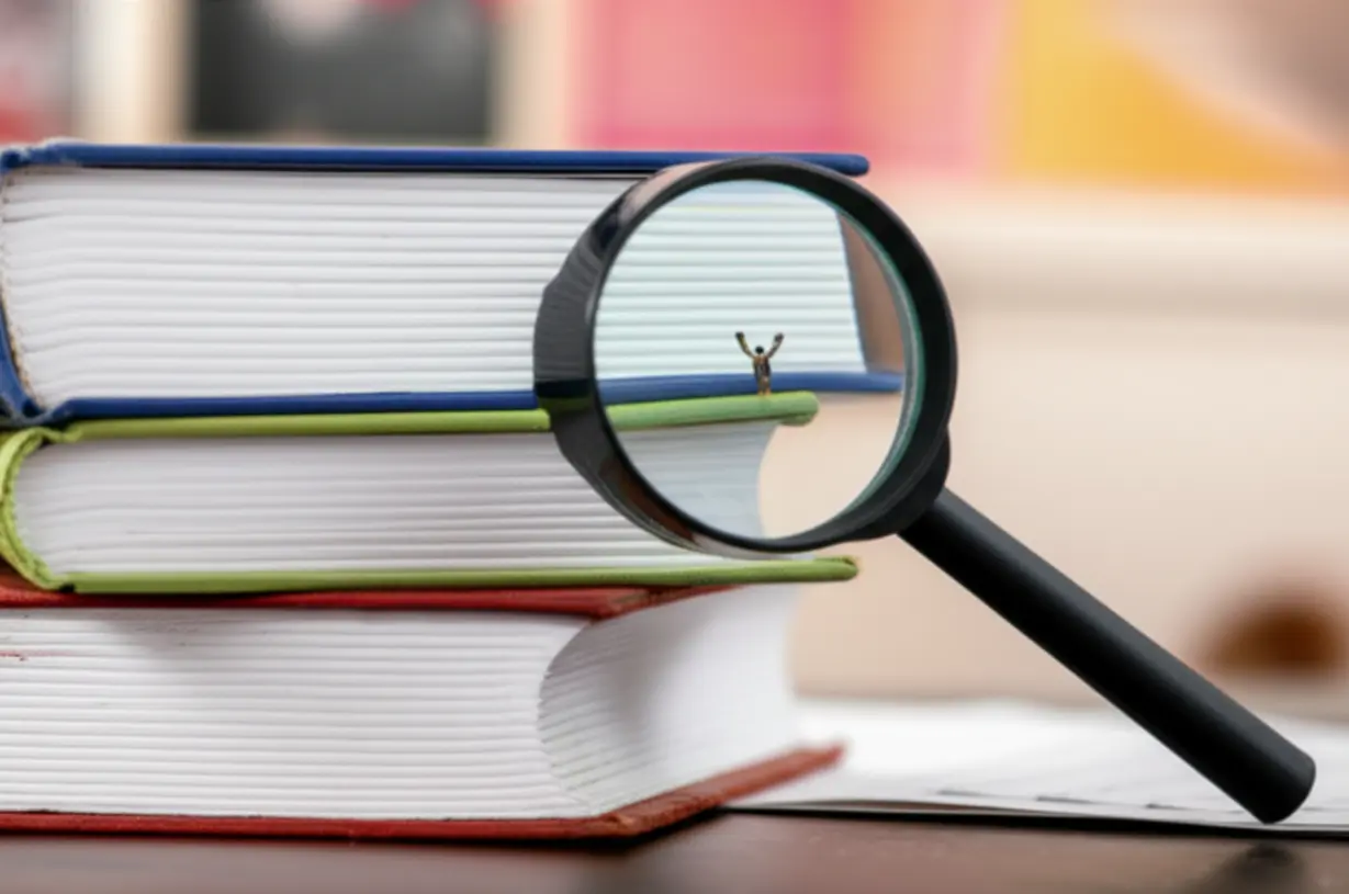 모서리가-살짝-흠집-난-영어-원서를-돋보기로-자세히-들여다보고-있는-모습