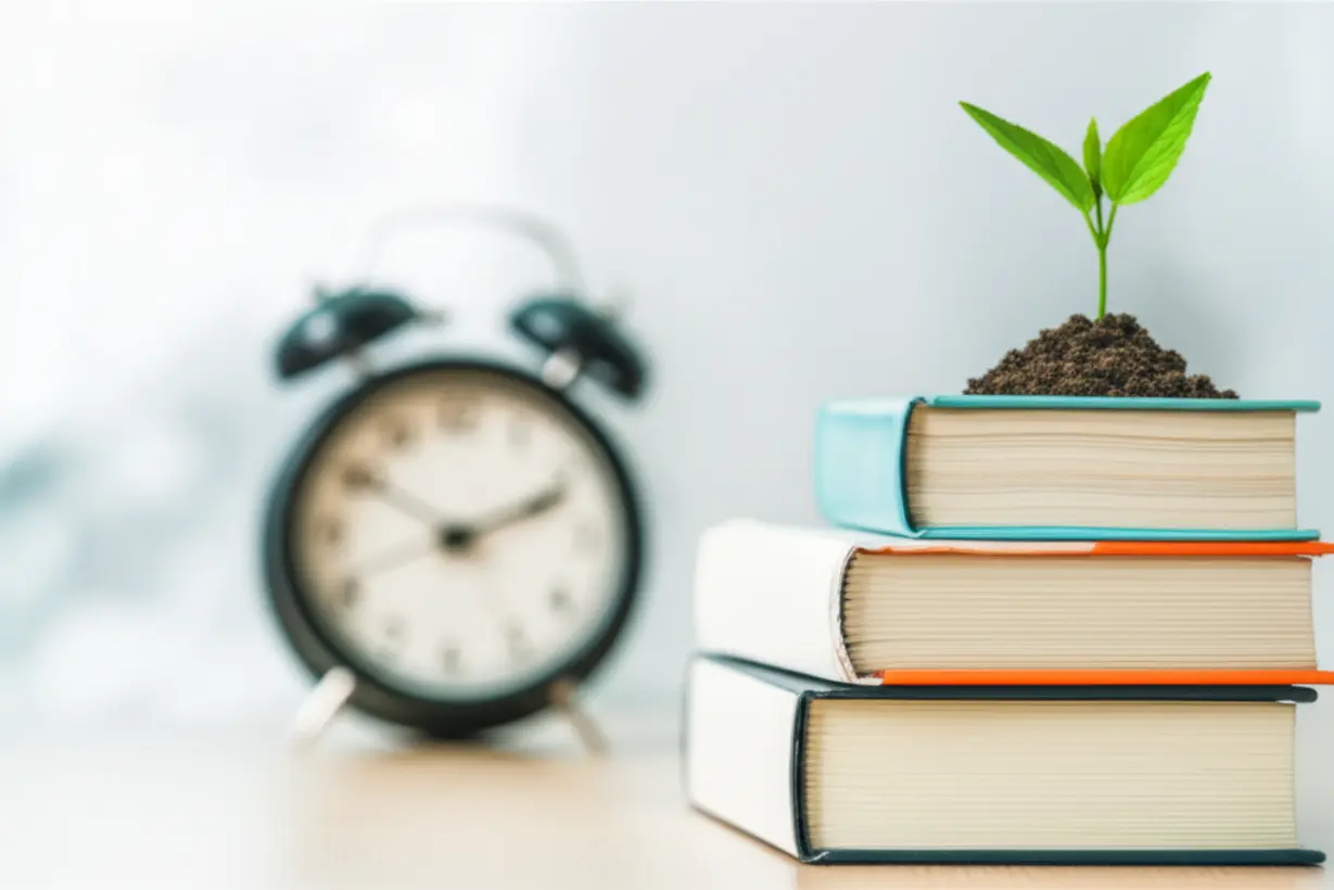 A-cute-3D-image-of-a-stack-of-neatly-arranged-books-next-to-a-small,-growing-plant,-symbolizing-consistent-growth-and-daily-effort.