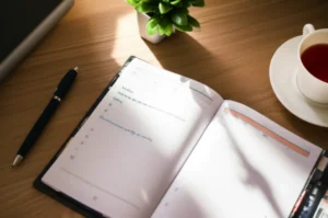 A-beautifully-organized-study-planner-open-on-a-desk,-with-a-pen,-a-small-plant,-and-a-cup-of-tea.-Sunlight-falls-on-the-planner,-conveying-calm-productivity-and-growth.